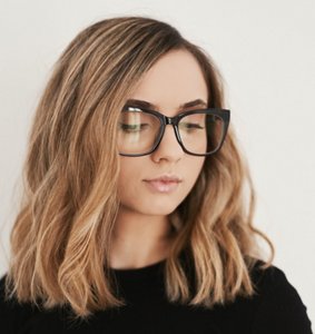 Woman wearing glasses with a long bob with blonde highlights